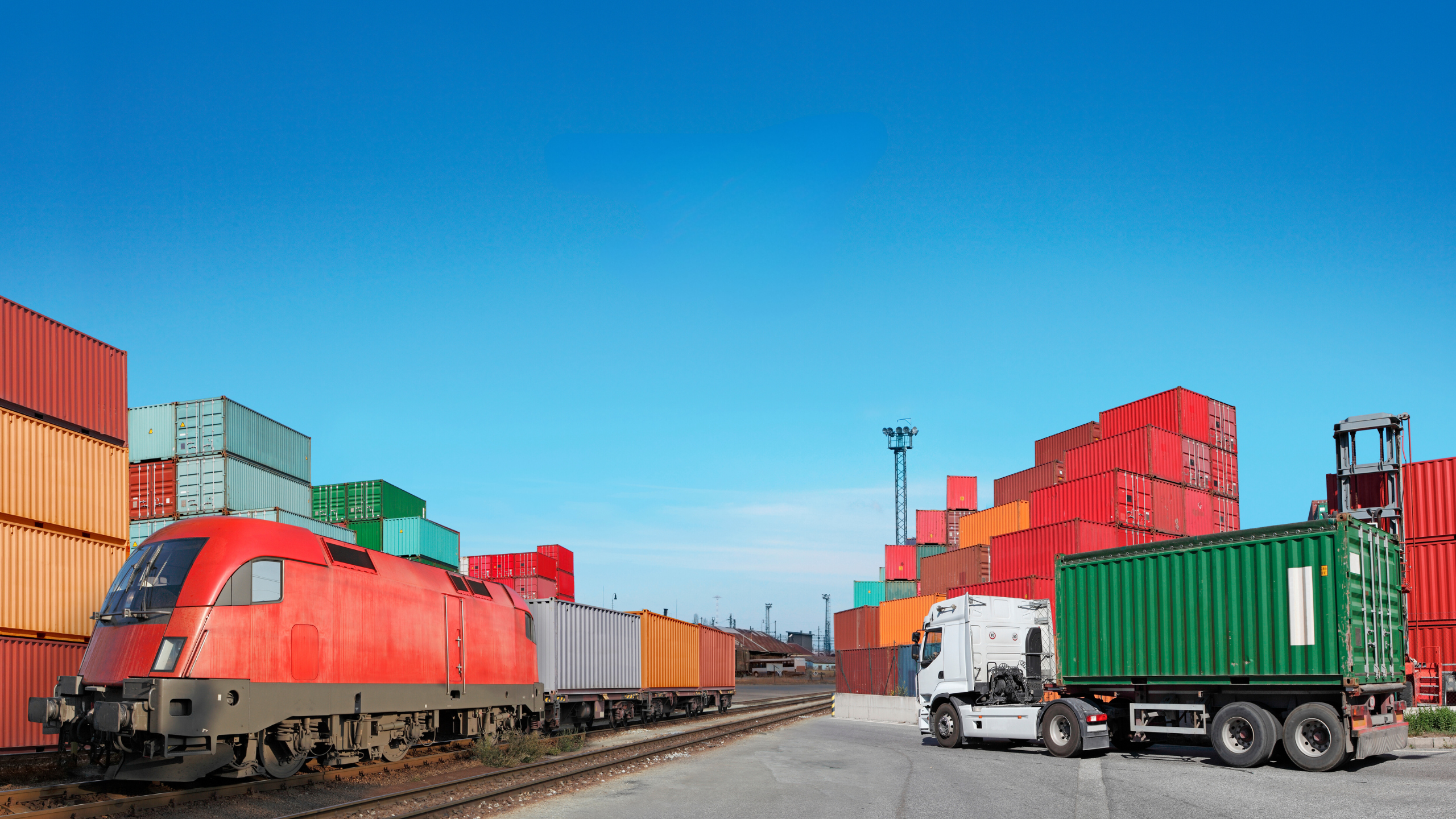 freight train and semi truck in a rail yard preparing for shipping